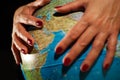 Hands of a woman holding a globe of the planet earth with marked places to travel on vacation