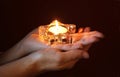 Hands of a woman holding a lit tea light in star shape Royalty Free Stock Photo