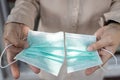 Hands of woman holding medical protective mask that was cut or destroyed that has been used before disposing of trash,prevent the Royalty Free Stock Photo