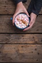 Hands of woman holding mug of hot chocolate drink with copy space at wooden table in cafe Royalty Free Stock Photo