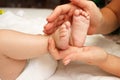 Hands of woman holds baby feet, blurred background Royalty Free Stock Photo