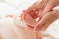 Hands of woman holds baby feet Royalty Free Stock Photo