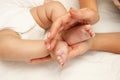 Hands of woman holds baby foot, blurred background Royalty Free Stock Photo