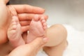 Hands of woman holds baby foot, blurred background Royalty Free Stock Photo