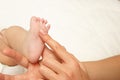 Hands of woman holds baby foot, blurred background Royalty Free Stock Photo