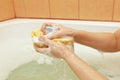 Hands of woman lathering a yellow sponge in bathroom Royalty Free Stock Photo