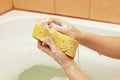 Hands of woman lathering yellow sponge with soap Royalty Free Stock Photo