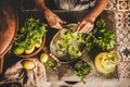 Woman decorating cold citrus homemade lemonade with fresh mint leaves