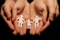 The hands of a woman and a man holding out a paper family, with the concept of conceiving a family. Royalty Free Stock Photo