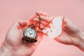 Hands of woman and man holding a silhouette of a child and clock. Paper silhouette and time before the birth of the child. Light