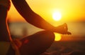 Hands of woman meditating in yoga pose at sunset on beach Royalty Free Stock Photo