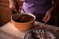 Hands of a woman mixing ground walnut with cocoa, raisins and Turkish delicacies in the kitchen. preparing a traditional cake reci