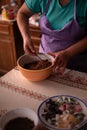 Hands of a woman mixing ground walnut with cocoa, raisins and Turkish delicacies in the kitchen. preparing a traditional cake reci