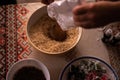 Hands of a woman mixing ground walnut with cocoa, raisins and Turkish delicacies in the kitchen. preparing a traditional cake reci