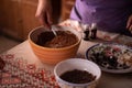 Hands of a woman mixing ground walnut with cocoa, raisins and Turkish delicacies in the kitchen. preparing a traditional cake reci