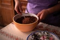 Hands of a woman mixing ground walnut with cocoa, raisins and Turkish delicacies in the kitchen. preparing a traditional cake reci