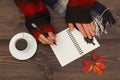 Hands of woman with a pen and notebook at a wooden table with cup of coffee and autumn leaves and scarf Royalty Free Stock Photo