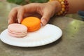 Hands of the woman picked a macaron