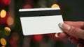 Hands of a woman in with a credit card on the background of a Christmas tree close-up. Christmas and New Year Royalty Free Stock Photo