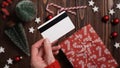 Hands of a woman in a red sweater with a credit card on a background of gift boxes, selective focus, close-up. Christmas and New Royalty Free Stock Photo