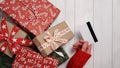 Hands of woman in red sweater holding credit card and gift box on white background close-up,top view,flat lay,copy space.Christmas Royalty Free Stock Photo