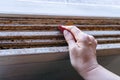 Hands of a woman with a sandpaper sanding a window frame before painting. Empowered woman concept Royalty Free Stock Photo