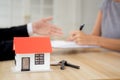 Hands of woman signing agreement and contract for buying house with realtor agent at office. Royalty Free Stock Photo