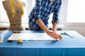 Hands woman Tailor working cutting a roll of fabric on which she Royalty Free Stock Photo