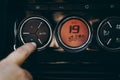 Hands of woman turning car air conditioning system. Button on dashboard to cold air in new car - orange panel. Photo of climate Royalty Free Stock Photo