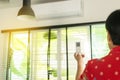 Hand using a remote control to activating air conditioning at reception room