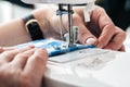 Hands of a woman using a sewing machine in tailor shop Royalty Free Stock Photo