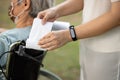 Hands of woman using tissue paper entwine handlebar of   wheelchair instead of touch her hands,wheelchair at the hospital,avoid Royalty Free Stock Photo
