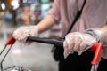 Hands of woman wearing plastic gloves pushing a shopping cart,prevent spread infection of COVID-19,Coronavirus,plastic gloves