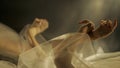 Hands of a woman with white tulle on a black background close up. A mirror reflects the blurred silhouette of a woman Royalty Free Stock Photo