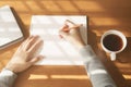 Hands woman writing notebook. On wooden desk background have coffee cup and laptop in morning  light Royalty Free Stock Photo