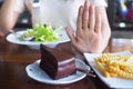 The hands of women care for health and diet, pushed from the chocolate cake and french fries plate. And choose eat vegetable or