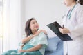 Hands woman doctor reassuring her female asian patient in hospital room,Doctor giving a consultation and encouragement to patient Royalty Free Stock Photo