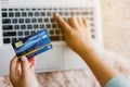 Hands women holding credit card and using laptop.