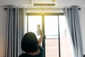 Hands woman using on off a remote control to activating air conditioning system in bedroom