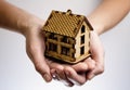 Hands with wooden house model.