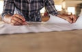 Craftsman leaning on a bench reading furniture design blueprints Royalty Free Stock Photo