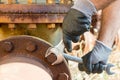 Hands with Work Gloves Holding a Wrench and Tighten very Rusty Bolts Royalty Free Stock Photo