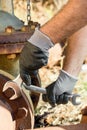 Hands with Work Gloves Holding a Wrench and Tighten very Rusty Bolts Royalty Free Stock Photo