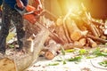 Hands of worker cutting the log by chainsaw machine with sawdust splash around. Motion blurred of sawing chainsaw