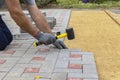 Hands of a worker in gloves laying concrete blocks with a rubber hammer Royalty Free Stock Photo