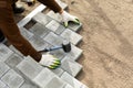 Hands of a worker installing concrete blocks, paving slabs with a rubber hammer Royalty Free Stock Photo