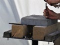 The hands of a worker Stonemason with chisel at work, stone slab on wooden blocks for processing Royalty Free Stock Photo