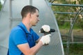 The hands of the worker twist the polycarbonate sheet with a screwdriver for installation on the greenhouse Royalty Free Stock Photo