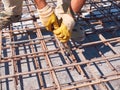 Hands of worker tying reinforcement rebars with haywire