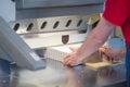 Hands of worker working on cutter guillotine machine in a printing factory Royalty Free Stock Photo